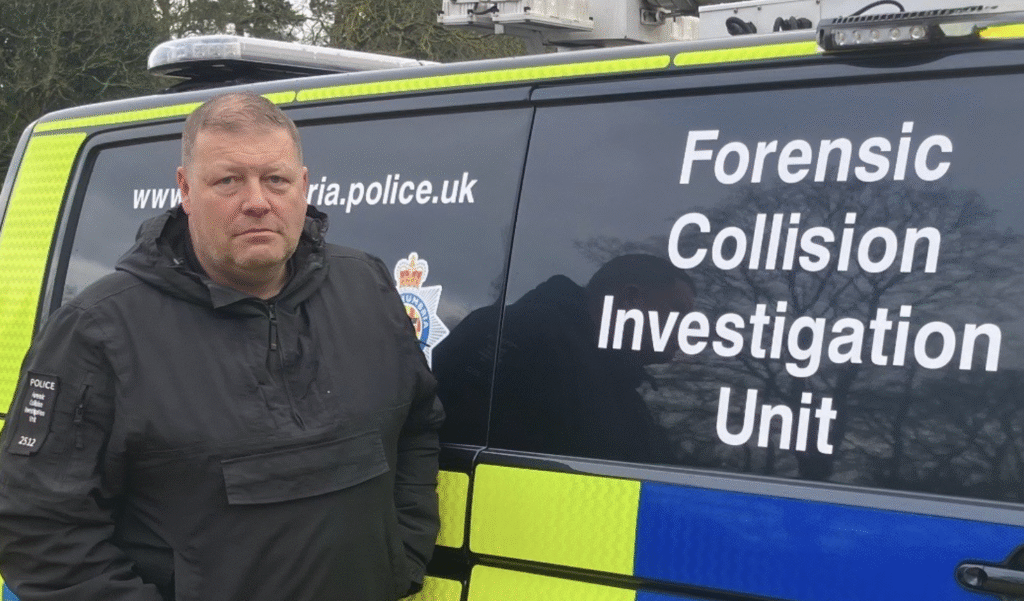 A man in a black police coat stands in front of the van with the words 'Forensic Collision Investigation Unit' written on the side.